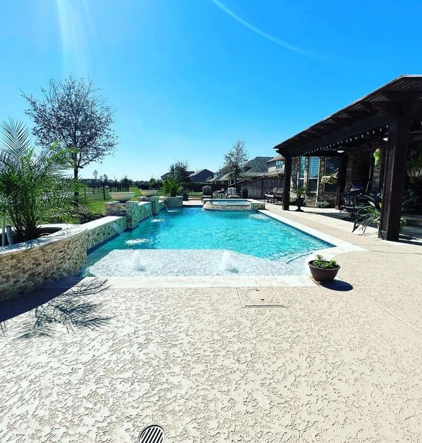 white natural sealed concrete sealed deck with a blue water
pool